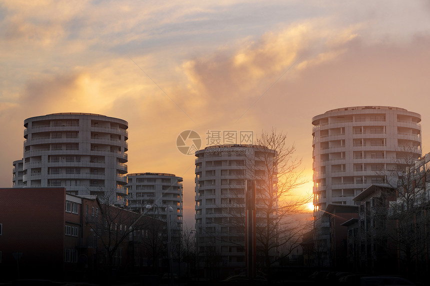 夕阳中的圆塔公寓城市里升图片