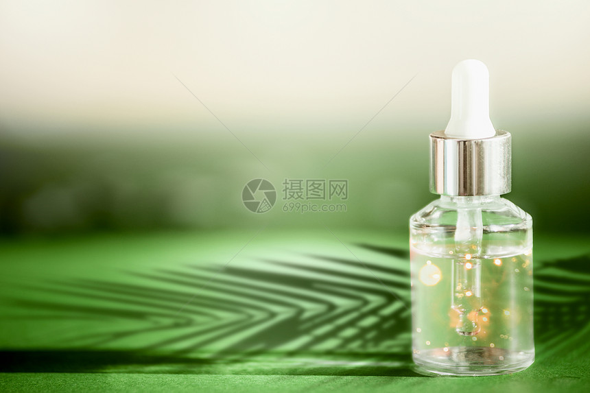 透明化妆瓶,吸管站绿色桌子上,棕榈叶阴影部皮肤护理天然素食化妆品血清皮肤精油现代美容趋势图片