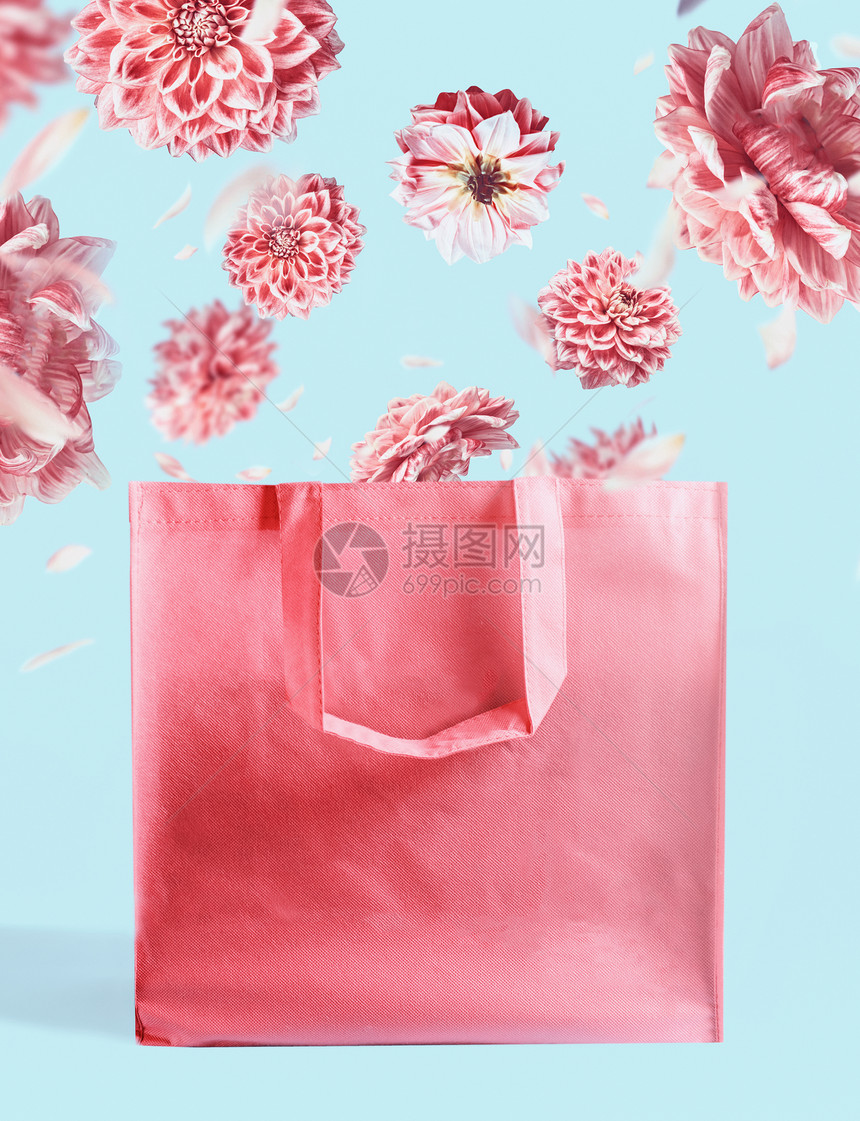 粉红色购物袋与飞花粉彩蓝墙背景品牌模拟创造的夏季图片