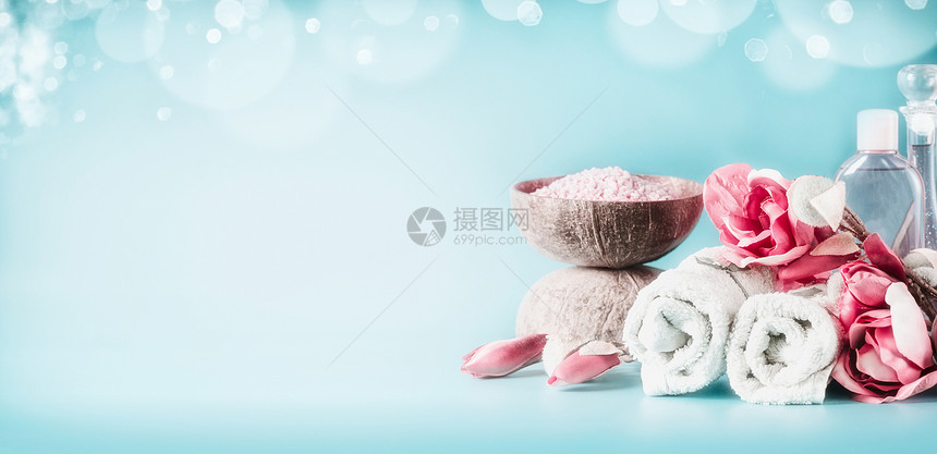 美丽的粉红色白色水疗中心毛巾,花,蜡烛,海盐身体护理化妆品浅蓝色背景与博克,横幅美丽的图片
