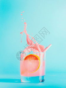 蓝色背景上用璃溅葡萄柚饮料夏季清爽饮料粉红色葡萄柚柠檬水果汁图片