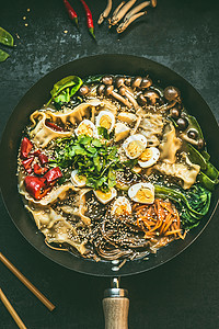 靠近炒锅与素食韩国火锅筷子黑暗的乡村厨房桌子背景,顶部视图亚洲食品图片
