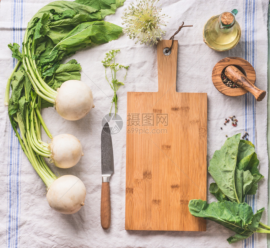 生幼萝卜与绿色轻厨房桌子上与空切割板刀,顶部视图健康素食清洁饮食烹饪理念图片