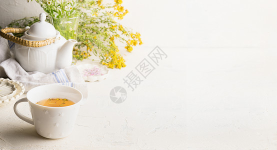 斗茶图草药茶背景与杯黄茶,茶壶新鲜草药花白色桌子墙上机土豆茶野生药用植物为您的产品背景