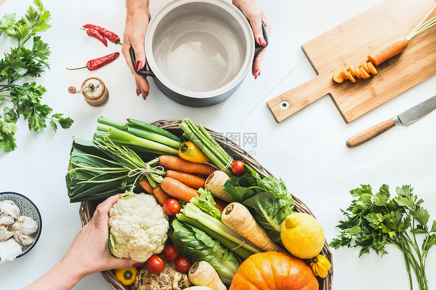 健康的生活方式女手白色桌子背景上用烹饪锅准备各种五颜六色的机农场蔬菜素食清洁季节饮食平躺的风景图片