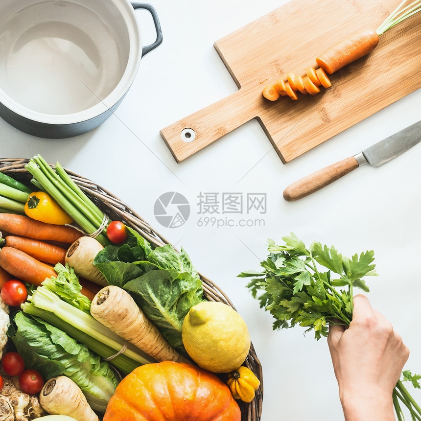 健康的季节蔬菜与烹饪锅,切割板刀白色桌子背景女手着新鲜的厨房草药干净的饮食农场机蔬菜的风景图片