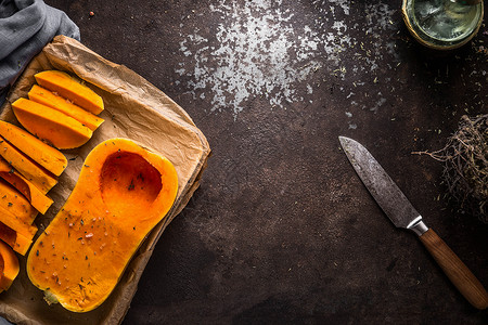 食物背景与奶油南瓜烤盘上的黑暗乡村背景与刀,顶部视图秋季季节烹饪饮食图片