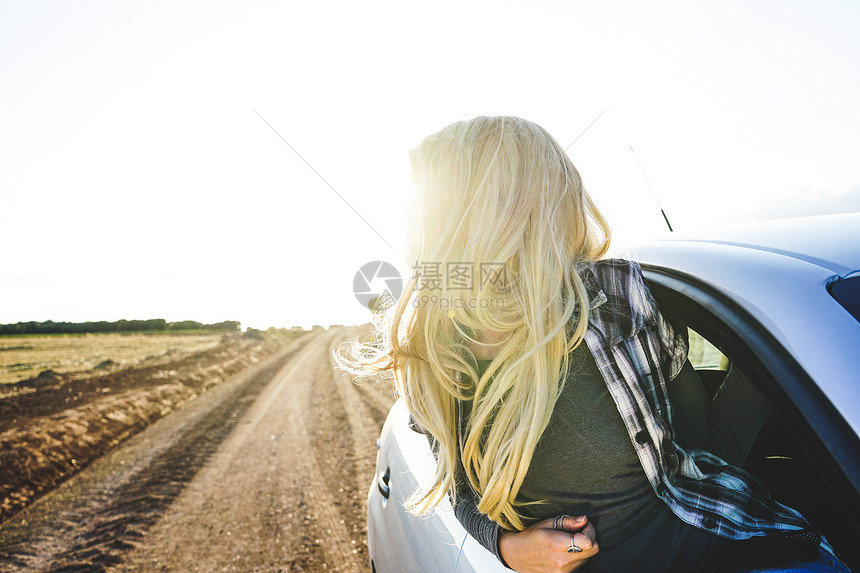 轻的女人次公路旅行中享受着旅程图片