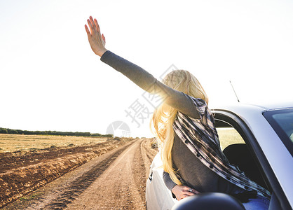 轻的女人次公路旅行中享受着旅程背景