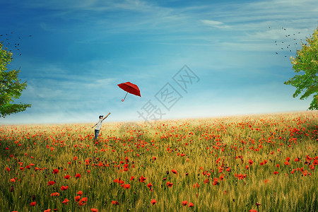 小男孩站片乡间草地上,百万只红,试图抓住他飞向天空的红色雨伞追求幸福成功的理念生活的快乐,乐趣幸福背景图片