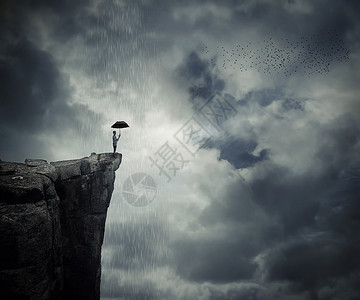 发伞鸟着伞的人站悬崖边上,叫雨云层上方的神秘地方背景