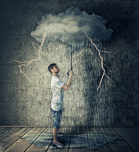 快乐的男孩站个房间里,着朵暴风雨的雨云雨伞商业悲观的图片