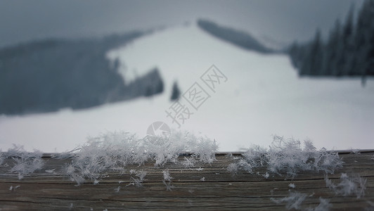 鳞片木板鳞片木桌上覆盖着柔软的雪花,背景美丽的山脉背景