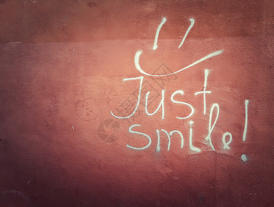 只微笑写红墙上,白色涂鸦笑脸符号混凝土纹理上图片