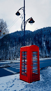 经典的红色英国电话盒,卡帕提安山锡那亚的雪地街道上图片