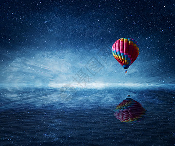 热气球飞海热气球飞过冰冷的深蓝色的大海美妙的景观,星空背景水反射背景