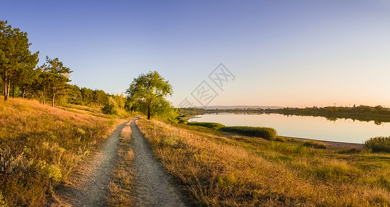 风景优美的乡村景观与乡村土路穿过片草地,晴朗的蓝天下,干草干草秋景观附近的德里亚湖,恩格尼,摩尔多瓦背景图片