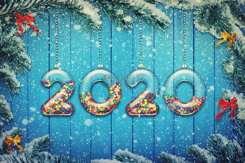 新快乐2020假期背景透明的数字,由璃制成,装满了五颜六色的糖果糖果,挂雪白的诞树树枝上图片