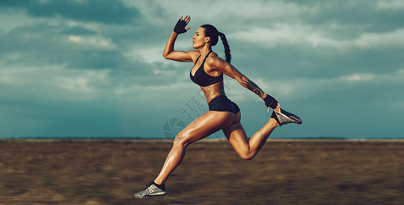 轻的肌肉运动女夏天的场地上跑得很快身上的纹身背景模糊的运动轻的运动女子跑步背景图片