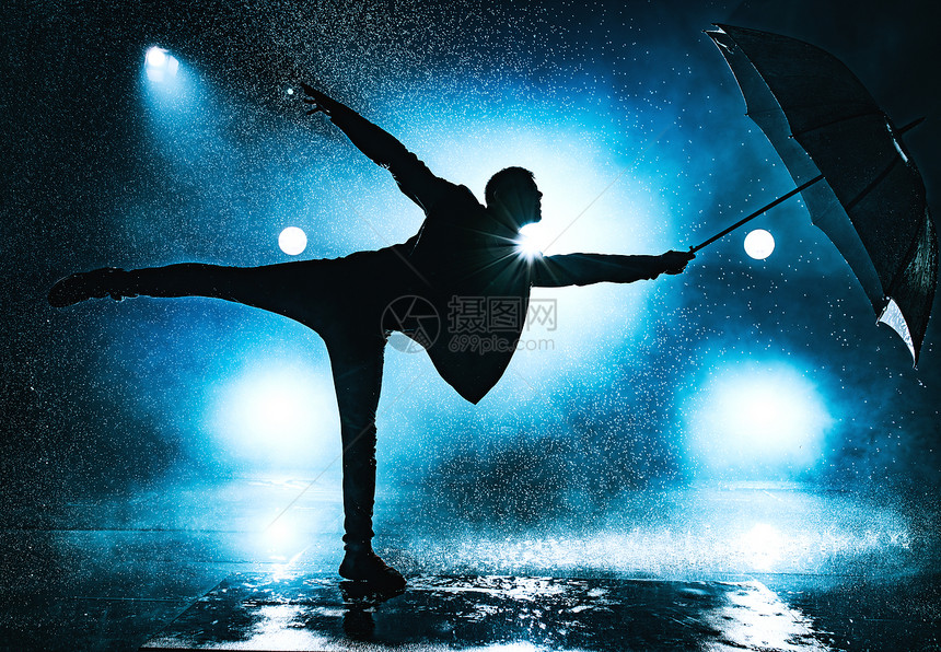 轻的奇怪男人雨下带着雨伞跳舞戏剧的蓝色带雨伞的人图片