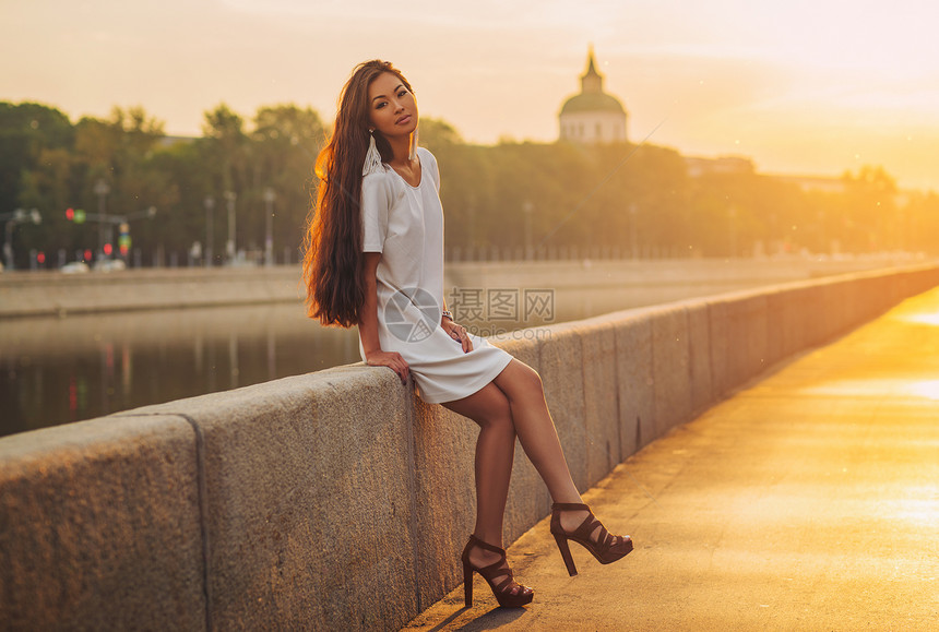 清晨日出时,轻的亚洲妇女坐城市石码头上柔软而美丽的肖像轻的亚洲女肖像图片
