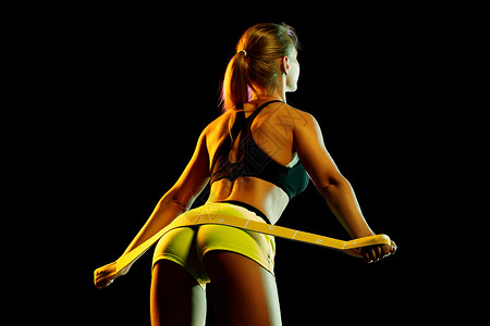 轻感的运动女健身运动的橡胶伸展双手黑色背景感的运动女人图片