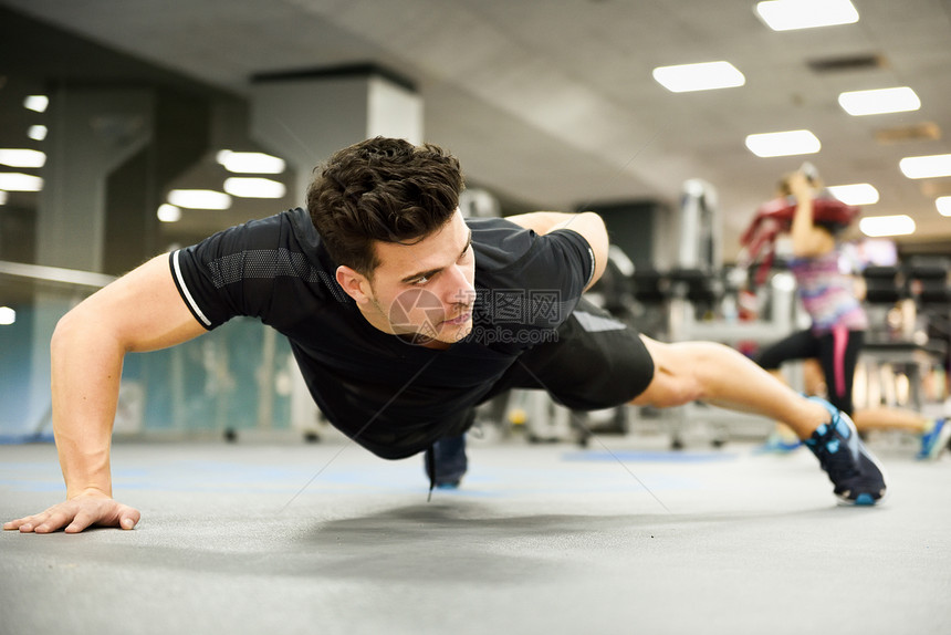 吸引力的男人健身房俯卧撑穿着运动服的家伙图片