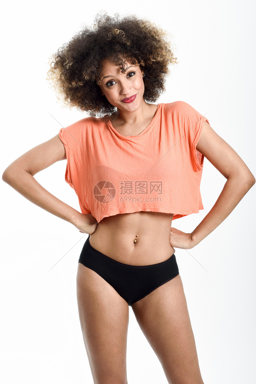 轻的黑人女人,留着AFRO的发型,微笑着穿着t恤黑色内裤的女孩摄影棚拍摄图片