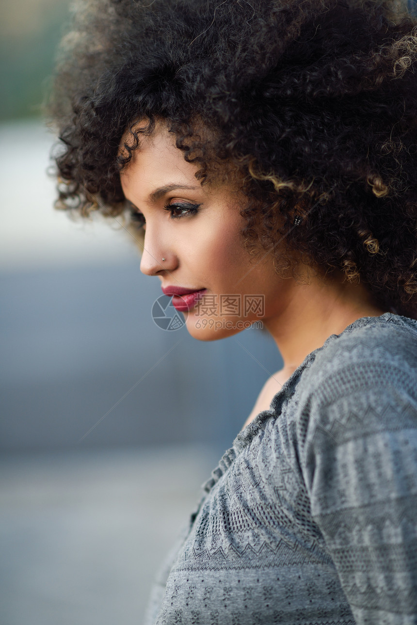 轻的混合女,留着AFRO发型,站城市背景中穿休闲衣服的黑人女孩图片