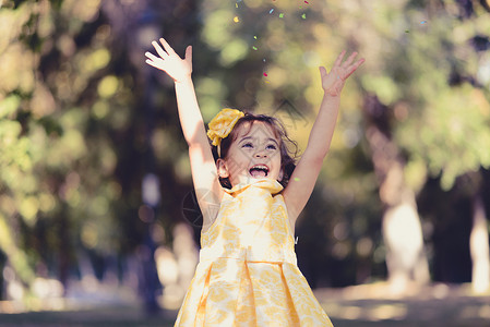 个小女孩穿着件漂亮的连衣裙公园里跑步玩耍的肖像图片