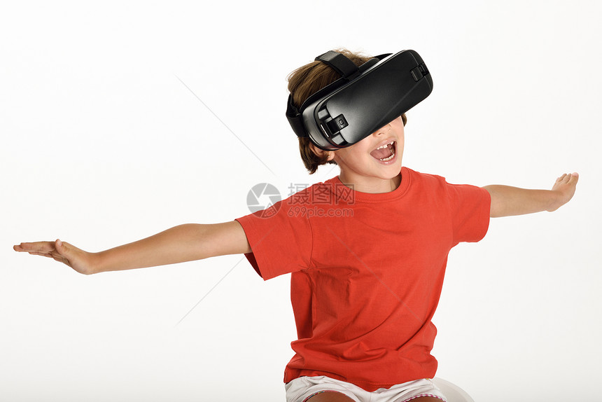 小女孩戴着虚拟现实眼镜,用手手势快乐惊奇的孩子戴着虚拟现实眼镜看电影玩电子游戏,隔离白色背景下图片
