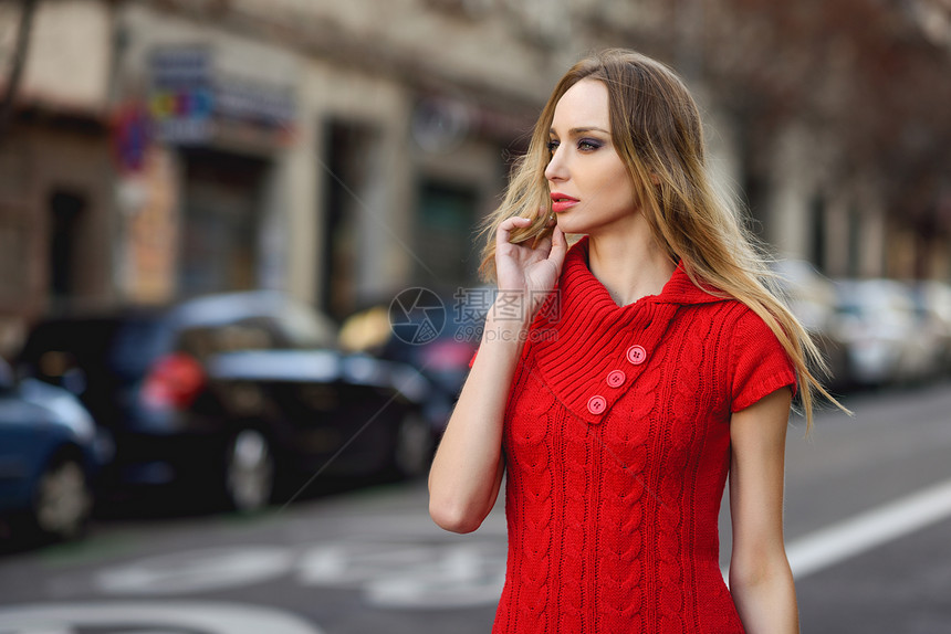 轻的金发女人看着街上的东西城市背景的漂亮女孩穿着红色的连衣裙直发的女图片