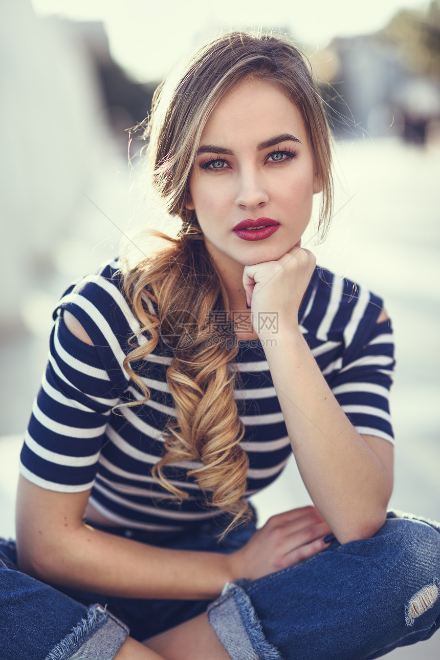 金发女人,时尚模特,坐城市背景的长凳上漂亮的轻女孩穿着条纹T恤蓝色牛仔裤街上漂亮的俄罗斯女,辫子图片