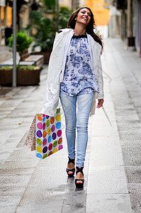 位带着购物袋走商业街的美丽女人的肖像图片