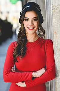 轻女的肖像,时尚模特,穿着红色连衣裙帽子城市背景上微笑图片