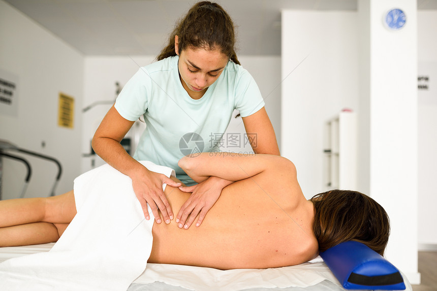 专业的女理疗师给住院的黑发女人腰肩按摩理疗中心肩部的医疗检查图片