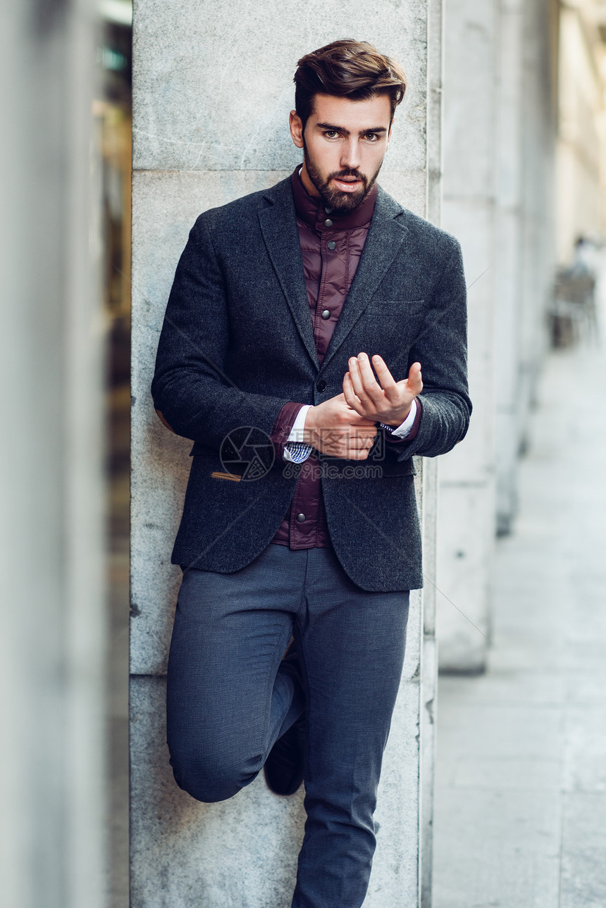 轻的胡须男子,时尚模特,城市背景下穿着英国优雅的西装街上留着胡子现代发型的家伙图片