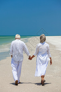 携手到老老男女夫妇携手热带海滩上散步的后视镜背景