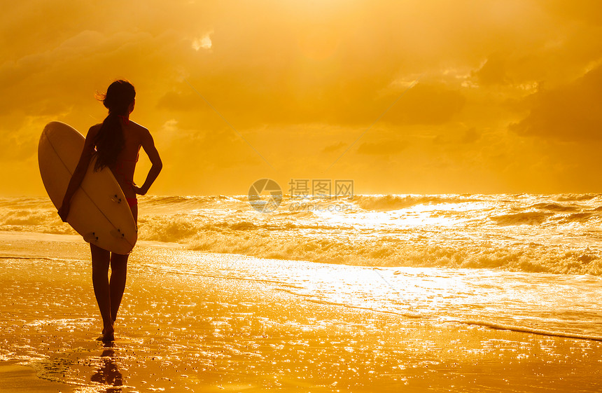 饱风格的后景美丽感的轻女子冲浪女孩比基尼与白色冲浪板海滩日落日出图片