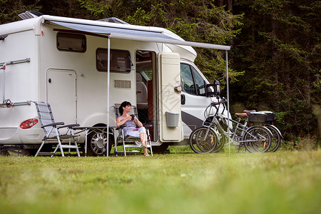 女人站露营车旁边着杯咖啡房车度假家庭度假旅行,度假旅行汽车房车图片