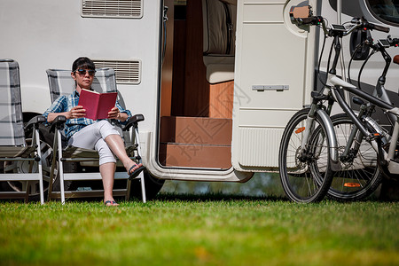 女人放松下来,野营附近读本书房车度假家庭度假旅行,度假旅行汽车房车图片