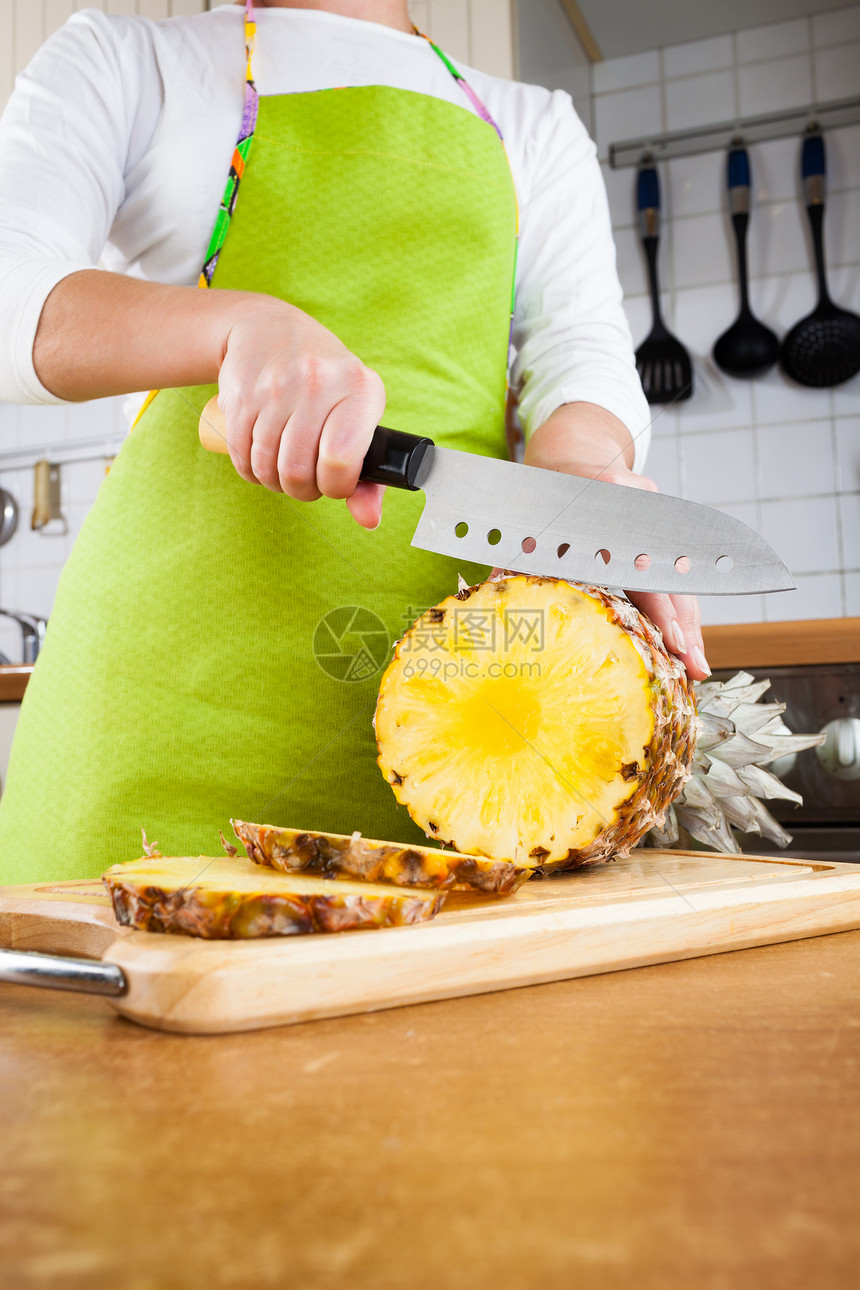 女人的手厨房里切新鲜菠萝图片