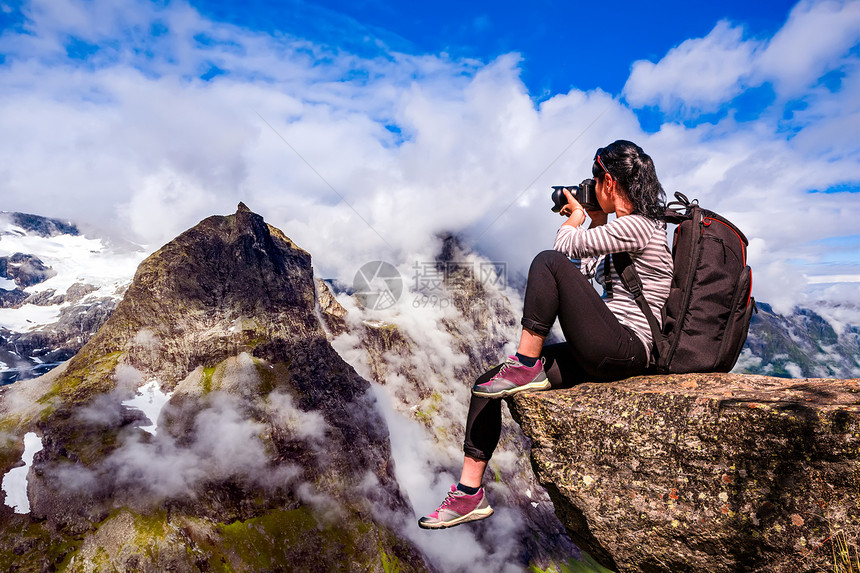 自然摄影师挪威自然摄影师游客与相机拍摄,同时站山顶美丽的自然挪威图片
