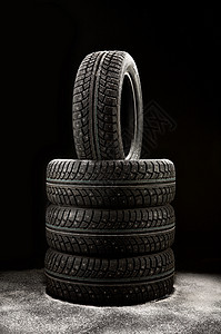 堆冬天的轮胎覆盖着黑色背景上的雪冬天的橡胶图片