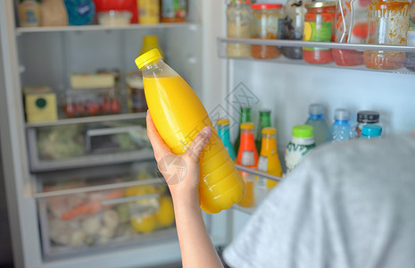 十几岁的女孩打开的冰箱里橙汁十几岁的女孩冰箱里橙汁图片