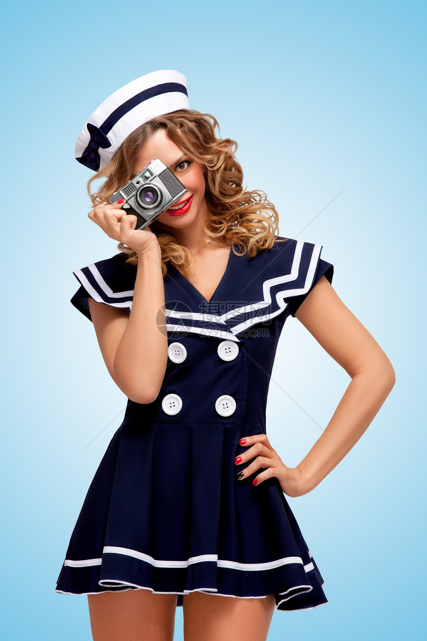 复古照片,个迷人的打扮水手女孩与个旧的老式照片相机情绪蓝色背景图片