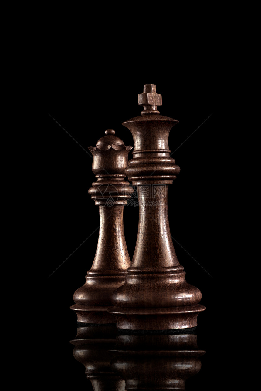 国际象棋游戏的黑色木制国王王后,最强大的人物站的黑暗背景图片