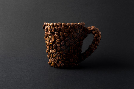 黑色背景下咖啡制成的杯子的创意照片图片