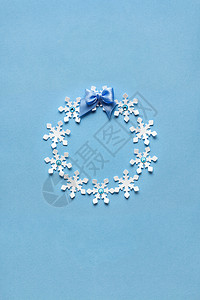 创意照片的诞花环由纸雪花制成的蓝色背景图片