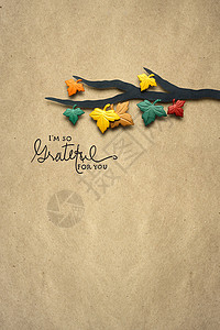 创意感恩节照片的树枝与树叶制成的纸张棕色背景背景图片